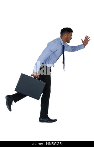 Businessman running with briefcase against white background Banque D'Images