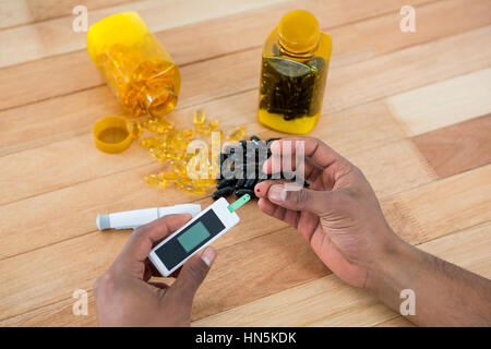 Close-up of mans part tester la glycémie glucomètre avec Banque D'Images