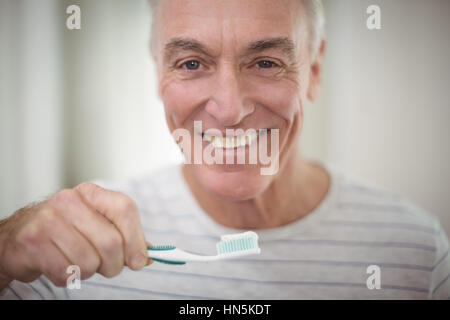 Portrait of senior man se brosser les dents dans la salle de bains à la maison Banque D'Images