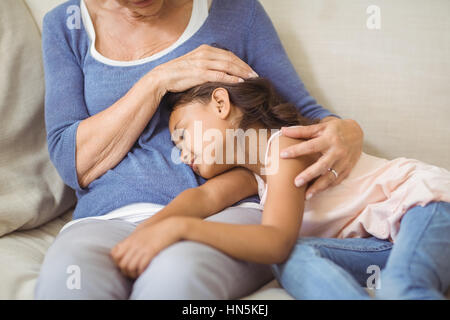 Petite-fille de dormir sur les grands-mères tour à la salle de séjour à la maison Banque D'Images