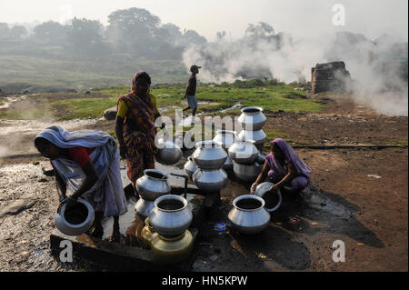 L'Inde, de l'État du Jharkhand, Dhanbad Jharia , certaines parties de l'smolding Jharia sont situés au-dessus de charbon souterraines et seront déplacés en raison de l'exploitation du charbon à ciel ouvert prolongé par BCCL Ltd. de charbon de l'Inde, les gens vont chercher de l'eau dans la matinée Banque D'Images