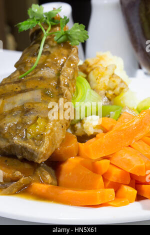 Une vue en gros plan d'un plat de steak de surlonge braisé servi avec une purée de pommes de terre et légumes. Banque D'Images