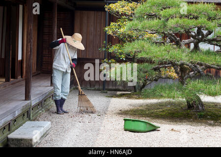 TAKAMATSU, JAPON - 8 mai : un jardinier ratisse le gravier dans le jardin Ritsurin, Takamatsu, Japon, le 8 mai 2012. Ritsurin est un jardin construit par t Banque D'Images