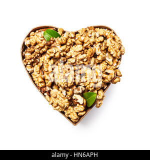 Les cerneaux de noix dans la boîte en forme de coeur comme la saine alimentation et de la médecine alternative concept, seul objet isolé sur fond blanc avec chemin, Banque D'Images