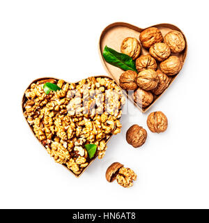 Les cerneaux de noix dans la boîte en forme de coeur, l'ensemble des noix et coquilles de l'alimentation santé et la médecine alternative, les objets concept isolated on white backgrou Banque D'Images