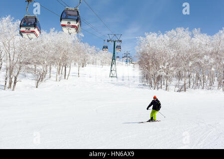NISEKO, JAPON - 9 mars : Un homme a passé des skis en télécabine de la station de ski Niseko Annupuri, le 9 mars 2012. Niseko est une grande station de sports d'hiver Banque D'Images