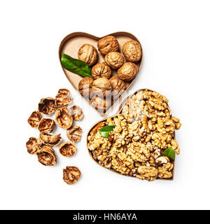 Les cerneaux de noix dans la boîte en forme de coeur, l'ensemble des noix et coquilles de l'alimentation santé et la médecine alternative concept, isolé des objets Banque D'Images