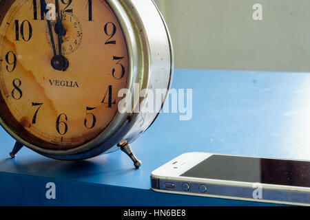 Ancienne tableclock ont été remplacés par les smartphones modernes à des fins multiples telles que des jeux, la gestion du temps et de prendre des photos Banque D'Images