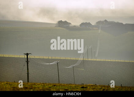 Les lignes électriques reliant une petite ferme à distance au réseau national, le parc national des South Downs au Ssussex Banque D'Images