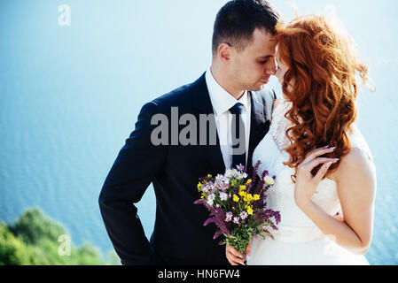 Gorgeous blonde Bride and Groom classy sur les rochers, au milieu de la se Banque D'Images