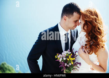 Gorgeous blonde Bride and Groom classy sur les rochers, au milieu de la se Banque D'Images