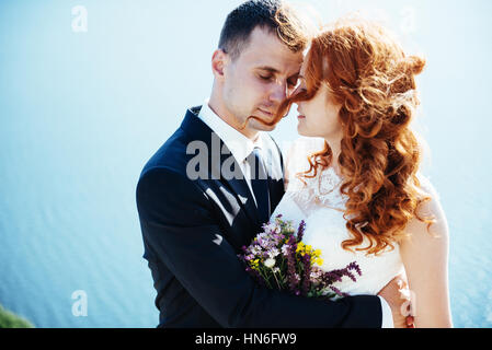Gorgeous blonde Bride and Groom classy sur les rochers, au milieu de la se Banque D'Images