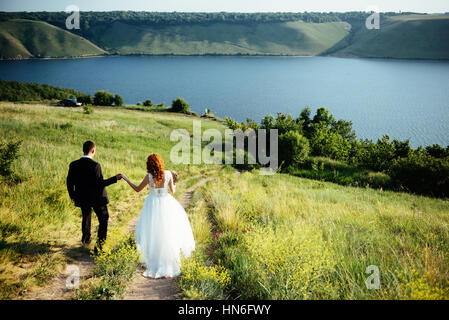 Gorgeous blonde Bride and Groom classy sur les rochers, au milieu de la se Banque D'Images