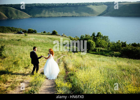 Gorgeous blonde Bride and Groom classy sur les rochers, au milieu de la se Banque D'Images