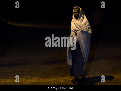 Pilgrim femme marche dans la nuit durant le festival Timkat, région d'Amhara, Lalibela, Éthiopie Banque D'Images