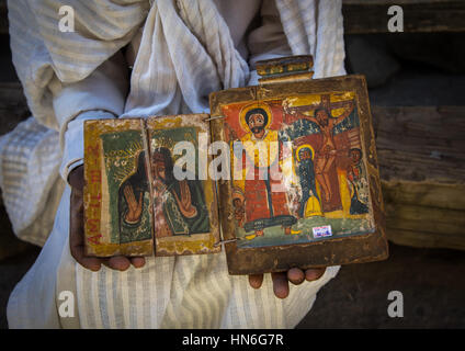 Prêtre de l'église éthiopienne orthodoxe de l'église Asheten mariam rock taillé est titulaire d'anciennes icônes illuminées, région d'Amhara, Lalibela, Éthiopie Banque D'Images