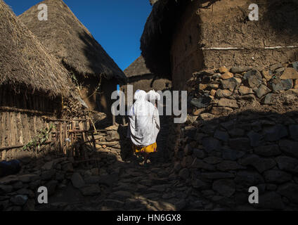 Femme éthiopienne marche dans un village de maisons en pierre dans les highlands, région d'Amhara, Debre Birhan, Ethiopie Banque D'Images