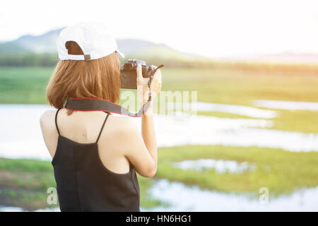 Prendre en photo fille d'Asie ont la nature et la montagne de l'eau à l'arrière-plan. Focus sélectif et doux soleil flare. Banque D'Images