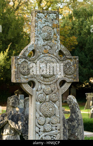 Croix celtique en pierre ornée d'une pierre tombale en cimetière de l'église St Mary Magdalene, Castle Ashby, Northamptonshire, England, UK Banque D'Images