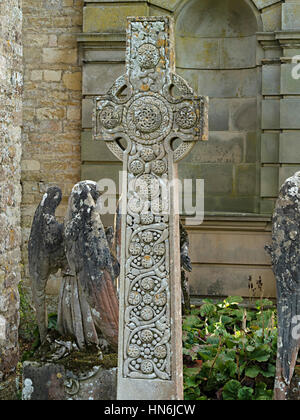 Croix celtique en pierre ornée d'une pierre tombale en cimetière de l'église St Mary Magdalene, Castle Ashby, Northamptonshire, England, UK Banque D'Images