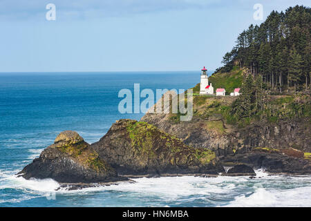 Vue côtière de phare de Heceta head à Yachats, Oregon avec le fracas des vagues et de la mousse des rochers Banque D'Images