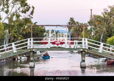 Venise, USA - 25 décembre 2015 : Couple en bateau sous pont-canal avec kiss signe et les gens dans la nuit Banque D'Images