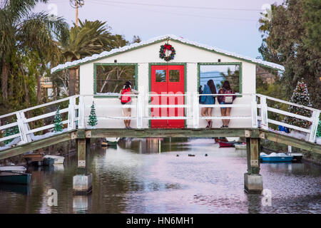 Venise, USA - 25 décembre 2015 : Trois femmes regardant hors de noël décoration windows sur pont-canal avec gerbe de neige et les arbres porte rouge Banque D'Images