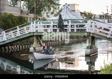 Venise, USA - 25 décembre 2015 : Couple en bateau avec rouge santa hats sous pont-canal romantique avec Snow Mountain et décoration d'arbre de Noël Banque D'Images