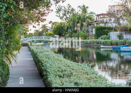 Venise, USA - 25 décembre 2015 : italien-comme les canaux verts à Los Angeles durant le coucher du soleil du soir avec des canoës et pont Banque D'Images