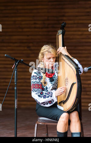 Silver Spring, États-Unis - 17 septembre 2016 : Larisa Pastuchiv-Martin habillés en costume brodé traditionnel assis jouant des instruments de musique de bandura Banque D'Images