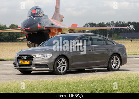VOLKEL, Pays-Bas - 15 juin 2013 : Audi A6 Limousine roulant en face d'un chasseur à réaction F-16 néerlandais au cours de la Royal Netherlands Air Force Open Day. Banque D'Images