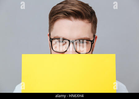 Portrait de beau jeune homme barbu tenant debout au-dessus de vide copyspace fond gris. Banque D'Images