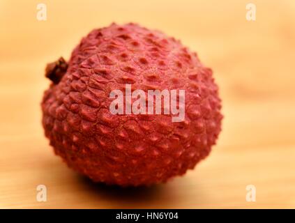 Un litchi sur un fond de bois. Banque D'Images