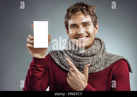 Heureux jeune homme à fort de médecine doigt pointé. Photo de l'homme malsain enveloppée d'écharpe. Concept de soins de santé Banque D'Images