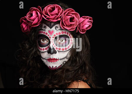 Visage peint pour l'halloween comme crâne sur woman isolated on black Banque D'Images