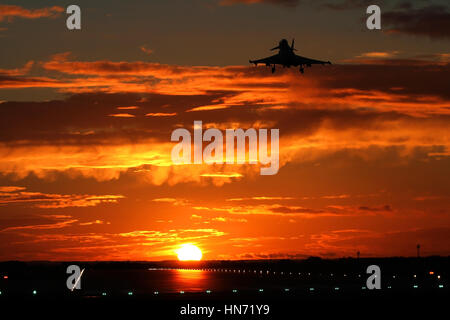 À tout droit la piste à RAF Coningsby au coucher du soleil. L'un des typhons de la base dépasse de nouveau dans le circuit visuel. Banque D'Images