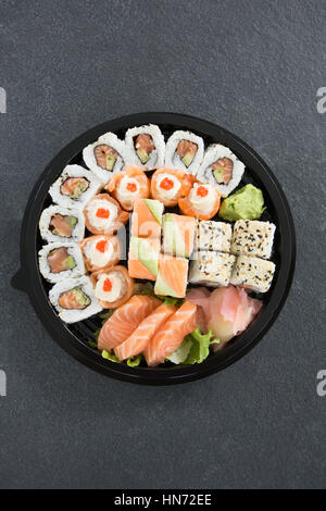 Différents rouleaux de sushi en plateau sur fond gris Banque D'Images