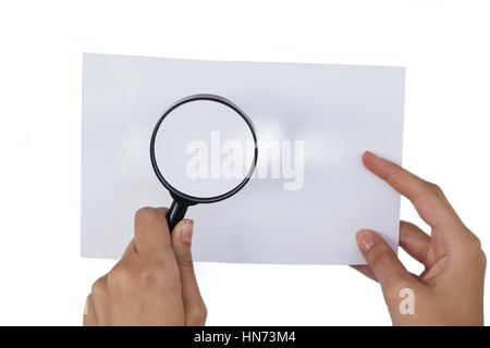 Close-up of woman holding loupe sur papier contre fond blanc Banque D'Images