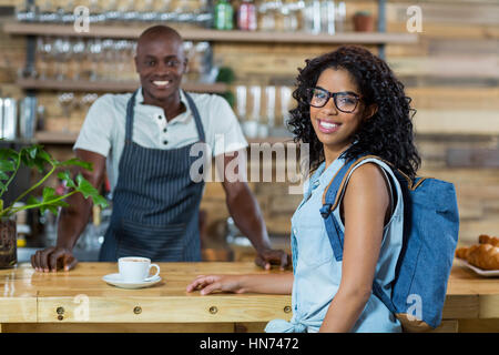 Portrait de femme et de serveur smiling at counter in cafÃƒÂ© Banque D'Images