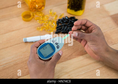 Close-up of mans part tester la glycémie glucomètre avec Banque D'Images