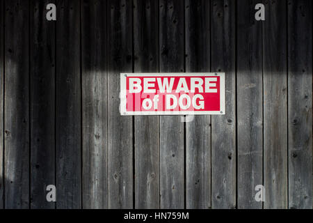 Attention au chien sign posted on old wooden fence Banque D'Images