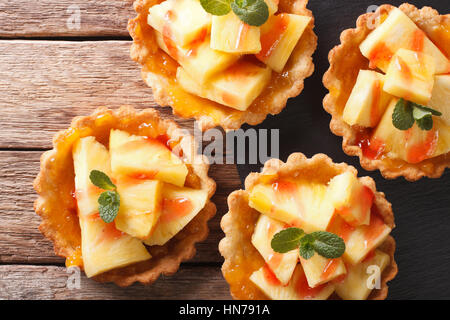 Tartelettes à l'ananas, de confiture et de menthe close-up sur la table horizontale vue du dessus. Banque D'Images