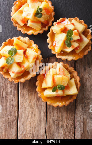 Mini Tarte fine à l'ananas et menthe close-up sur la table. vertical Vue de dessus Banque D'Images