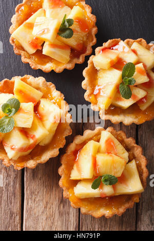 Tartelettes à l'ananas, de confiture et de menthe close-up sur la table. vertical Vue de dessus Banque D'Images