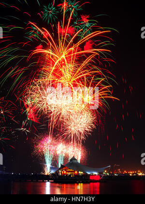 D'artifice spectaculaire explosion dans le ciel de nuit et silhouette de café sur une jetée à Lagoon Beach, Ancol, au nord de Jakarta. Tourné avec une exposition longue, te Banque D'Images