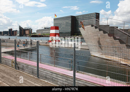 Un garçon sautant de la plongée sous-marine tour à les îles Brygge piscine extérieure, dans le port de Copenhague, Danemark Banque D'Images