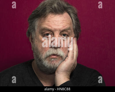 10 février 2017 - Portrait d'homme de race blanche âgé mddle sur fond rouge Crédit : Igor Golovniov/ZUMA/Alamy Fil Live News Banque D'Images