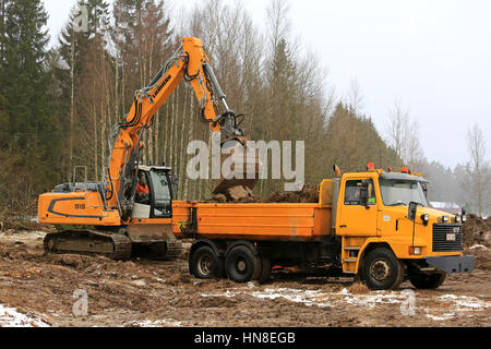 FORSSA, FINLANDE - le 28 janvier 2017 : pelle sur chenilles Liebherr R 918 sol charges sur Sisu jaune SR332 chariot bascule en hiver. Banque D'Images