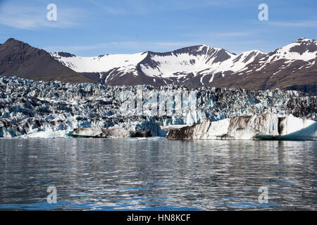 La glace est de la pac est glaciaire Vatnajokull Jokulsarlon glacial lagoon la réunion. Des traces de cendres volcaniques sombres peuvent être observées sur le glacier. Banque D'Images