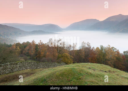 Vue sur Lac Grasmere au lever du soleil avec inversion de la brume de Heron Pike, Rydal a chuté, Grand Rigg et siège sandale de Red Bank, Grasmere, Lake District Na Banque D'Images